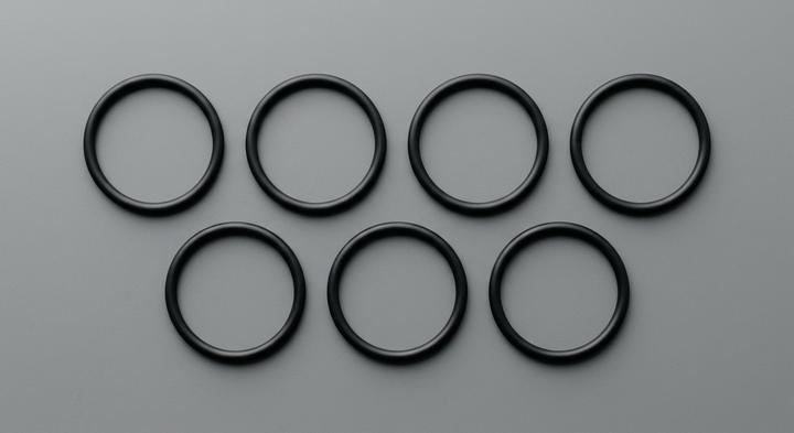 Minimalist clean layout of precision mechanical ring gaskets on a gray surface