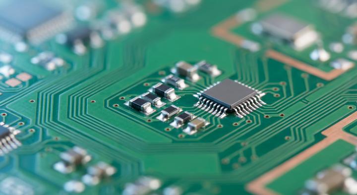 Close-up of a high-quality green printed circuit board with precise soldering and modern electronic components.