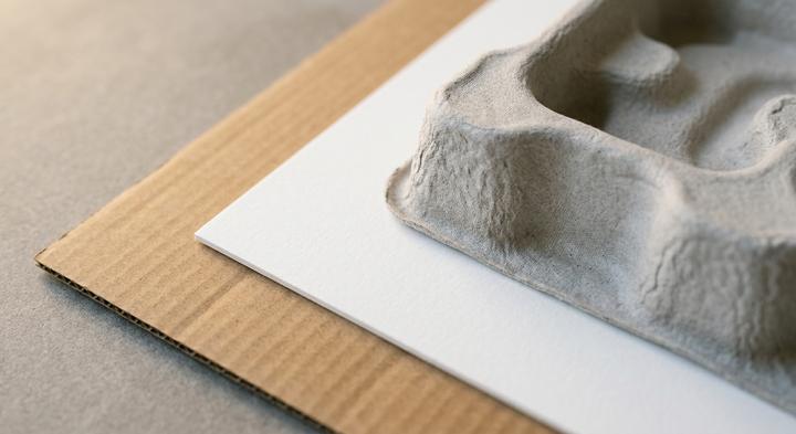 High-quality raw packaging materials including corrugated cardboard and molded pulp tray in a clean geometric layout